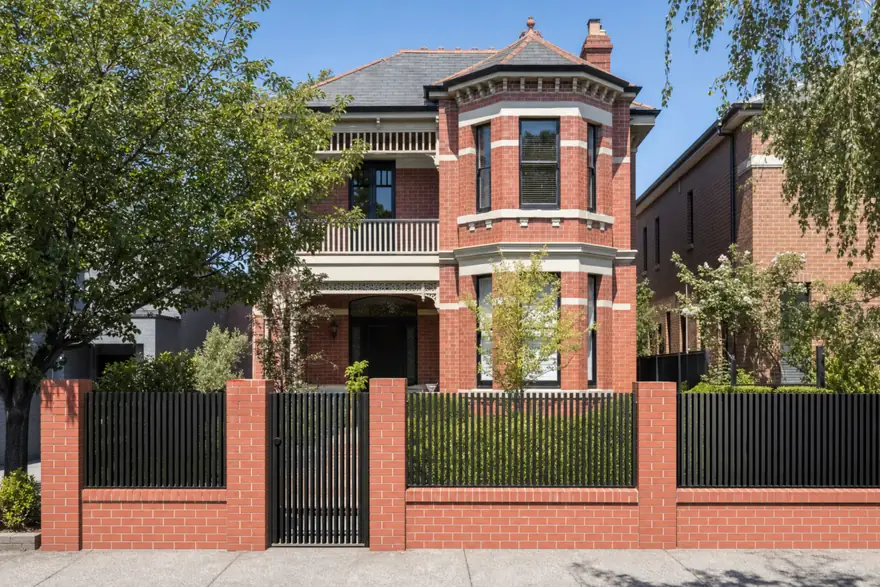 Made-to-measure black blade fence between brick pillars on a Melbourne Edwardian home